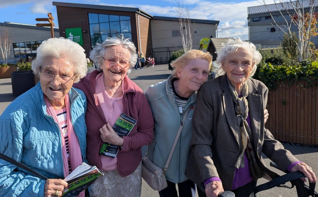 4 women standing outside of a garden centre smiling